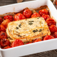 Baking pan filled with feta cheese, tomatoes, and pasta